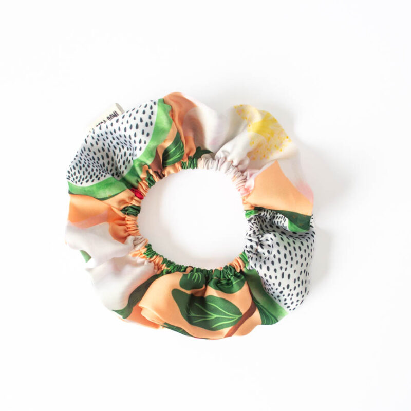 Scrunchie doble tricahue con ilustraciones de flora y fauna nativa de Chile, vista cenital para resaltar diseño