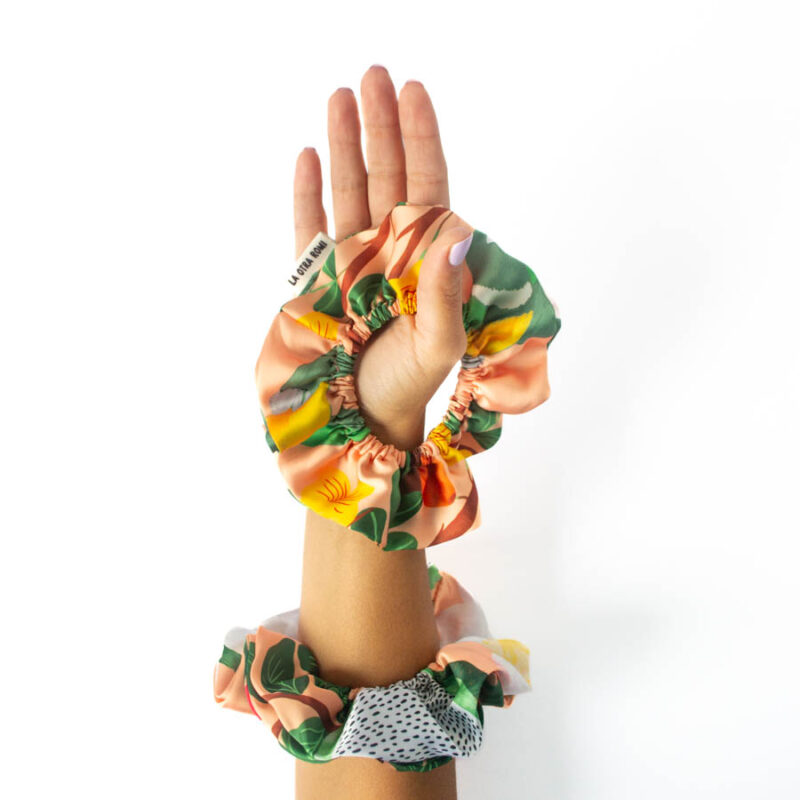 Scrunchie doble tricahue en muñeca y mano alzada, con ilustraciones de flora y fauna nativa de Chile, vista frontal