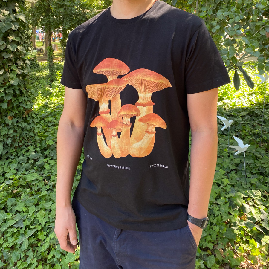 Polera unisex hongo de la risa en color negro con ilustración, utilizada por una persona en un entorno al aire libre